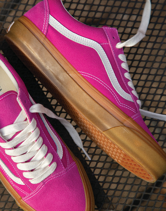 Close-up shot of Raspberry Pink Premium Old Skool shoes, laced and resting on a mesh surface.