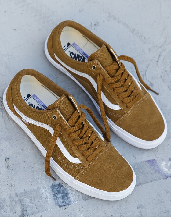 Close-up shot of Golden Brown BMX Old Skool shoes against a cement floor. 