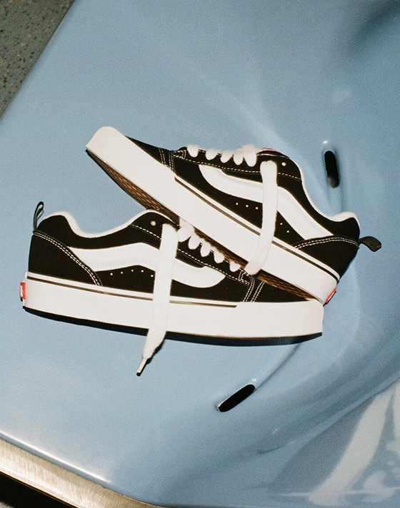 A close up of black knu skool shoes on a blue chair
