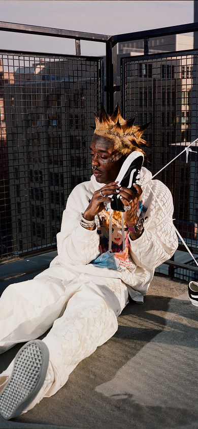 Lil Uzi Vert sits on a rooftop, holding the Vans Old Skool to their ear like a phone.