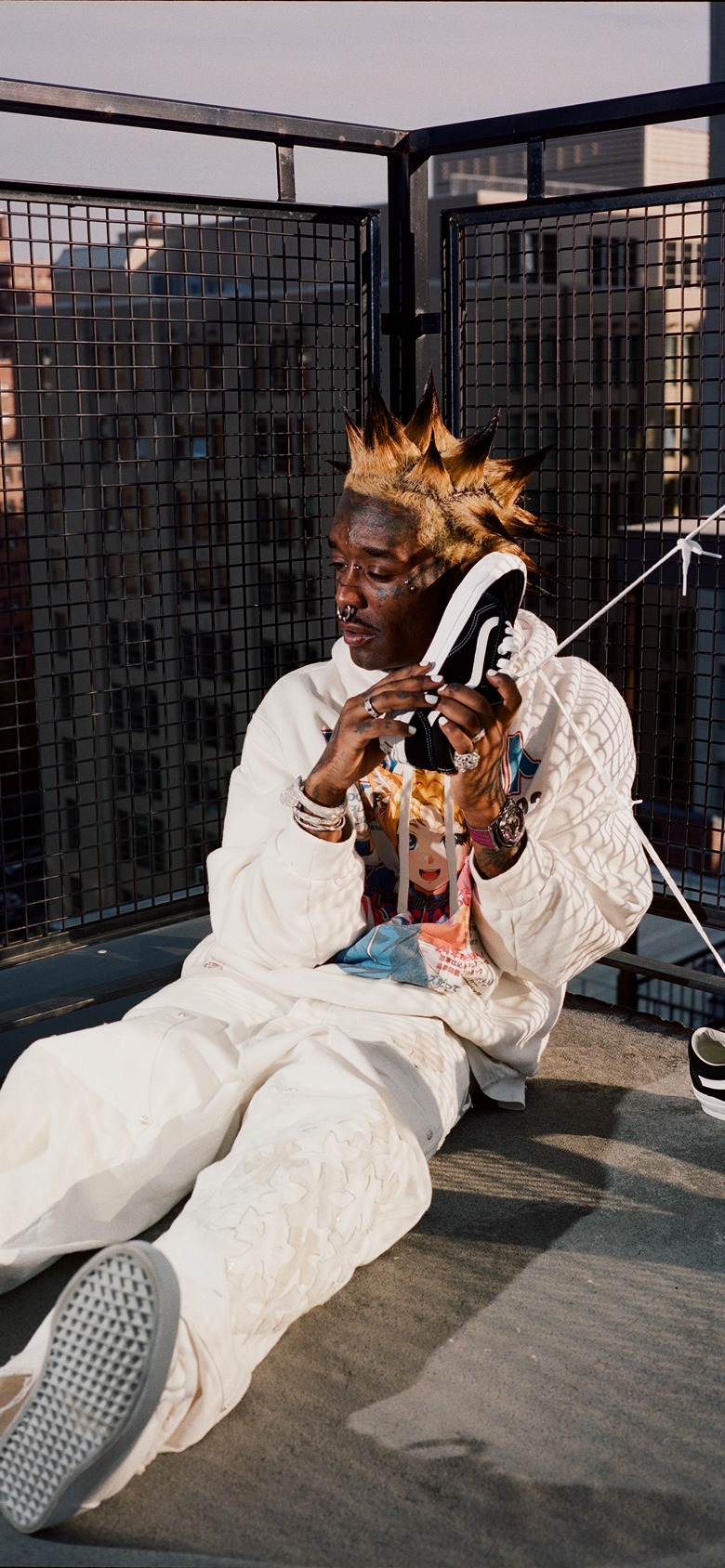 Lil Uzi Vert sits on a rooftop, holding the Vans Old Skool to their ear like a phone.