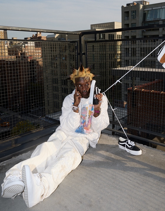 Lil Uzi Vert sits on a rooftop, holding the Vans Old Skool to their ear like a phone.