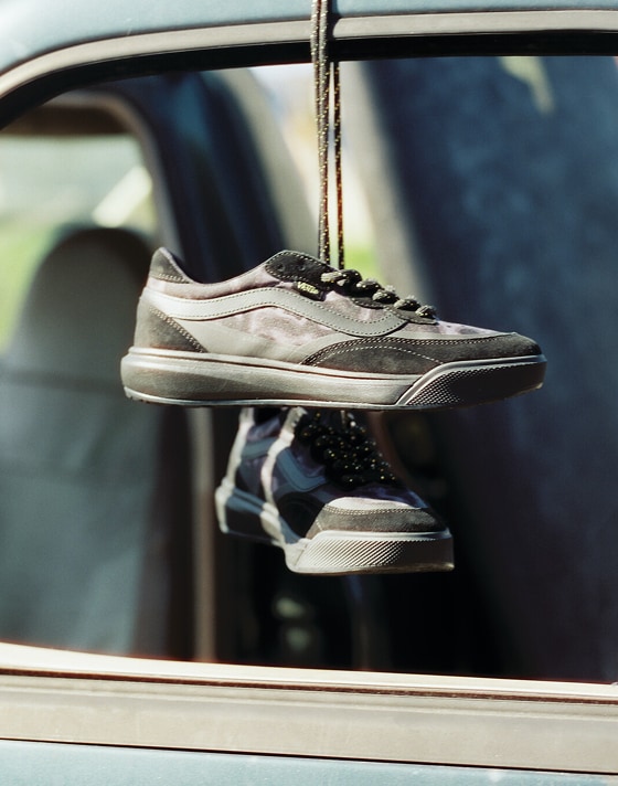 A pair of black UltraRange 2.0 hang from a truck door by their laces with the beach in the background.