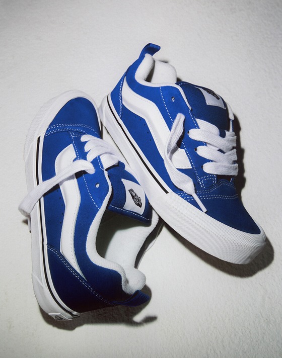 A pair of blue Knu Skool lie on the ground of a photography studio.
