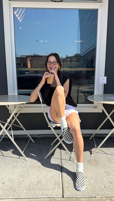 @yesconnieishere drinks an iced coffee wearing a black shirt, white shorts, and and black and white Checkerboard Classic Slip-On.	@yesconnieishere drinks an iced coffee wearing a black shirt, white shorts, and and black and white Checkerboard Classic Slip-On.