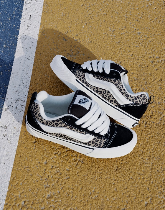 A pair of cheetah print Knu Skool rest on a colored court.