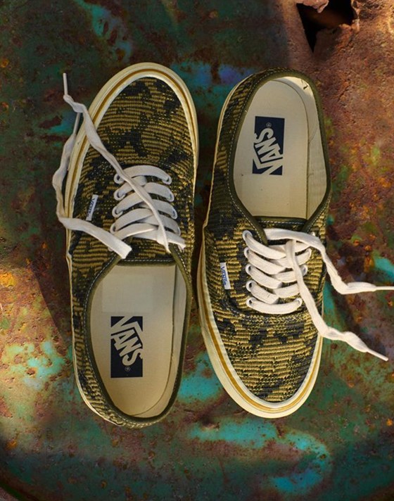A pair of antique gold and green Premium Authentic rest on top of a rusty oil drum in a warehouse.