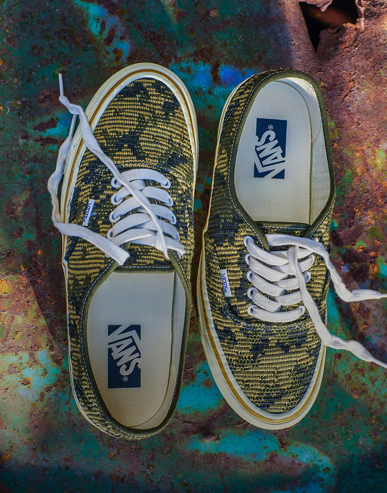 A pair of antique gold and green Premium Authentic rest on top of a rusty oil drum in a warehouse.