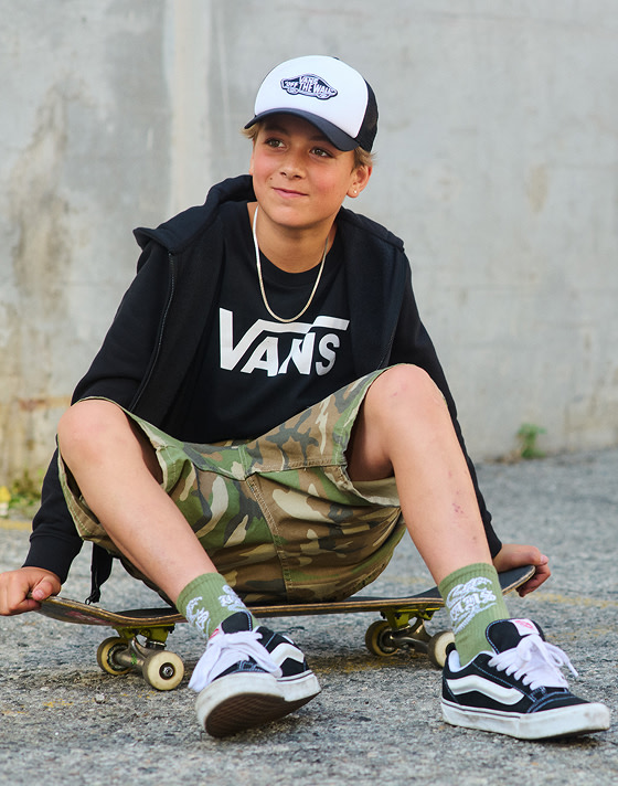 A close up of kids standing together, each wearing their favorite Vans shoe style.