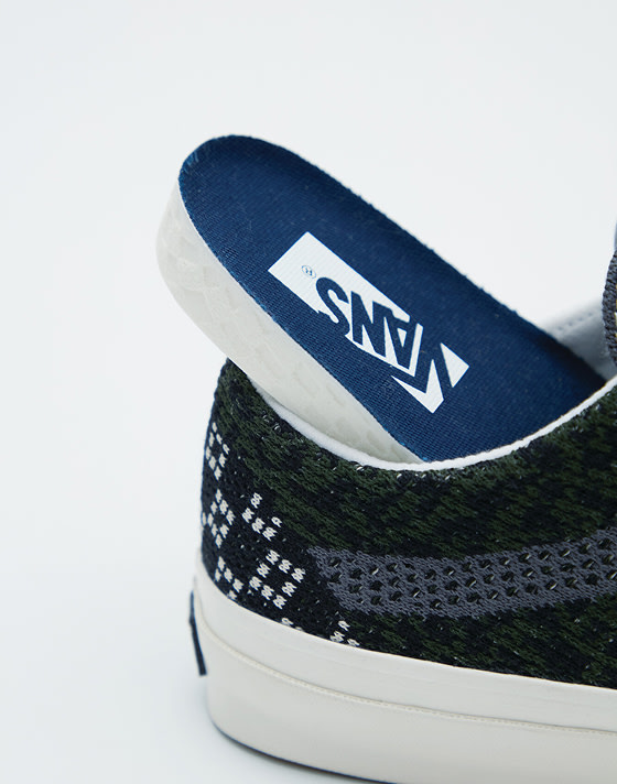 The blue sole of the Cheetah Dried Kelp Green Premium Old Skool resting on the lip of the sidewall so you can see the Vans logo on it.