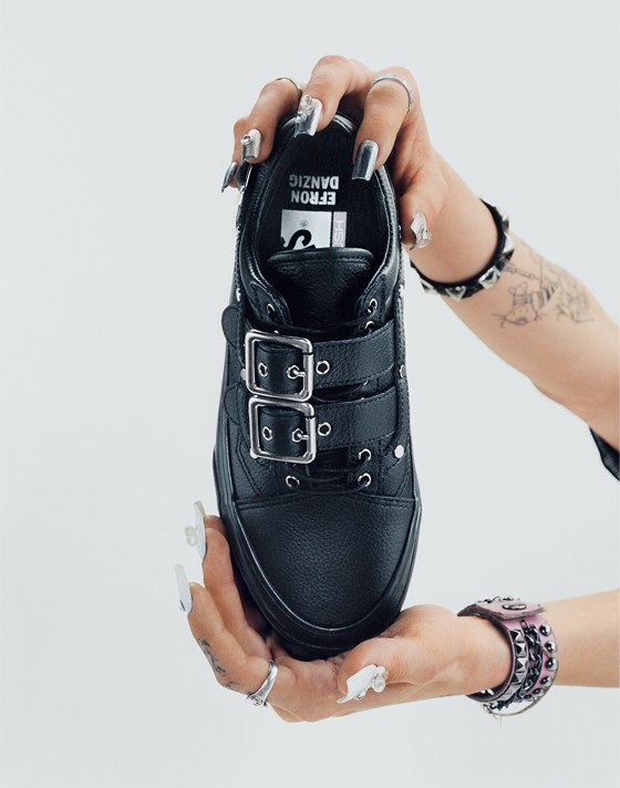 Vans Skater Efron Danzig holds up her Premium Old Skool in a photography studio with her name on the interior sole.