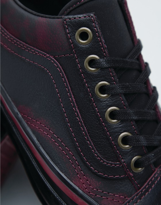 A close-up of the red-tinted leather and grommets on Tania Cruz’s Premium Old Skool.