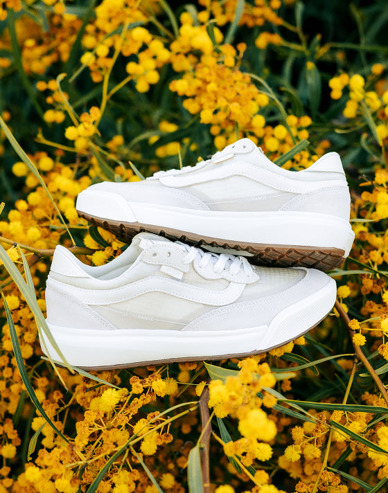 A pair of vintage white UltraRange 2.0 rest on some canary gold flowers.