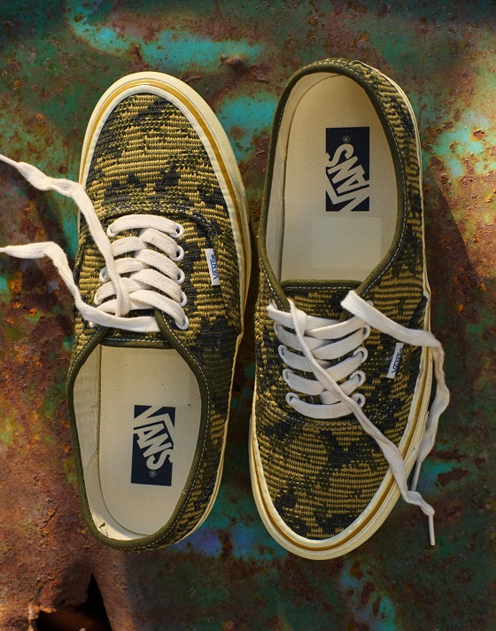 A pair of antique gold and green Premium Authentic rest on top of a rusty oil drum in a warehouse.