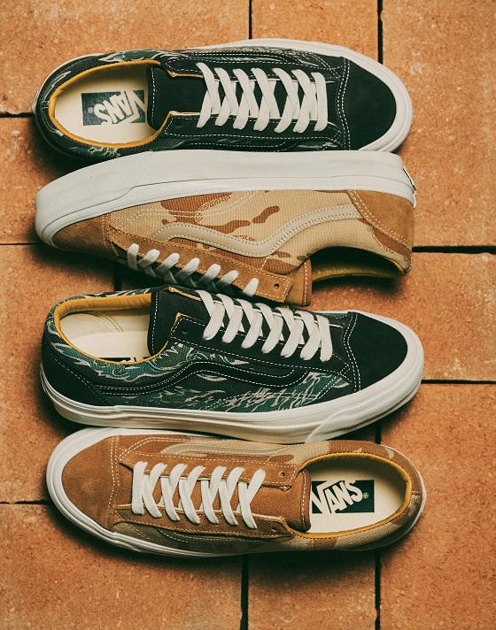 A pair of Old Skool with green flames and the other with brown camo lie on a brick floor.