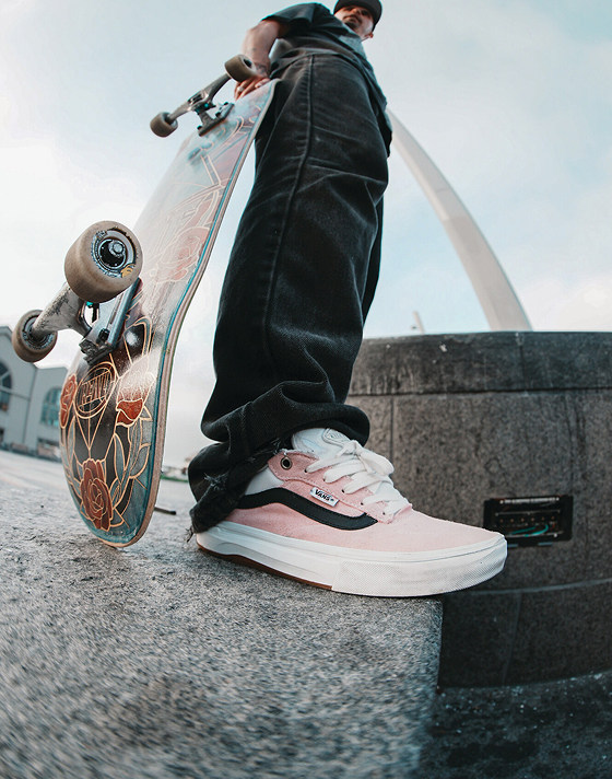 A fisheye shot of Kyle Walker holding a skateboard and wearing the Kyle Walker Wafflecup skate shoes.