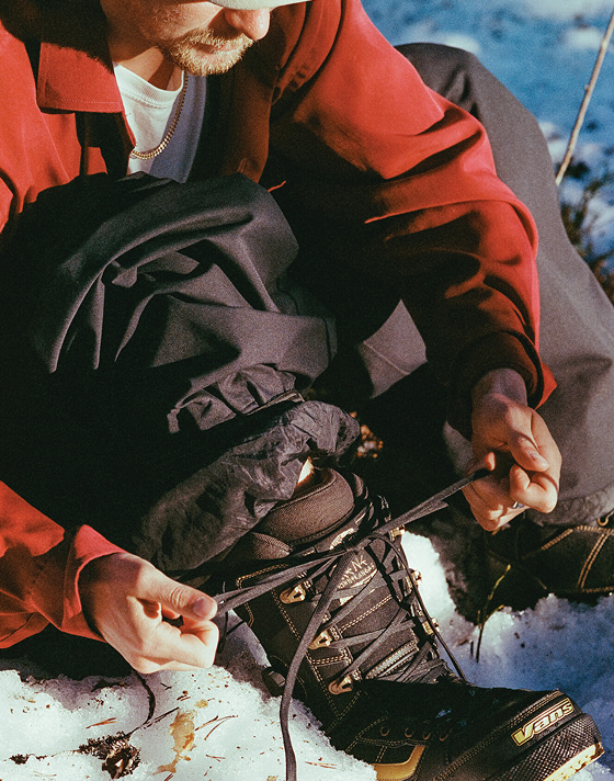 Vans Snowboard Team Rider Rene Rinnekangas lacing up his Invado Pro in the snow.