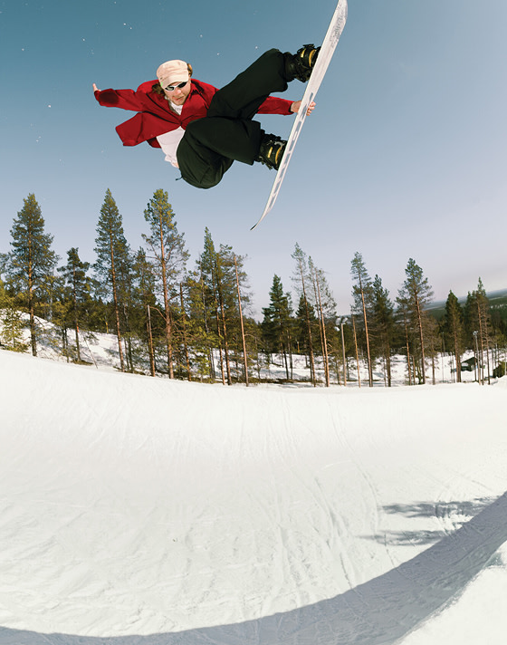 Vans Snowboard Team Rider Rene Rinnekangas catching air and grabbing his board in the Invado Pro.