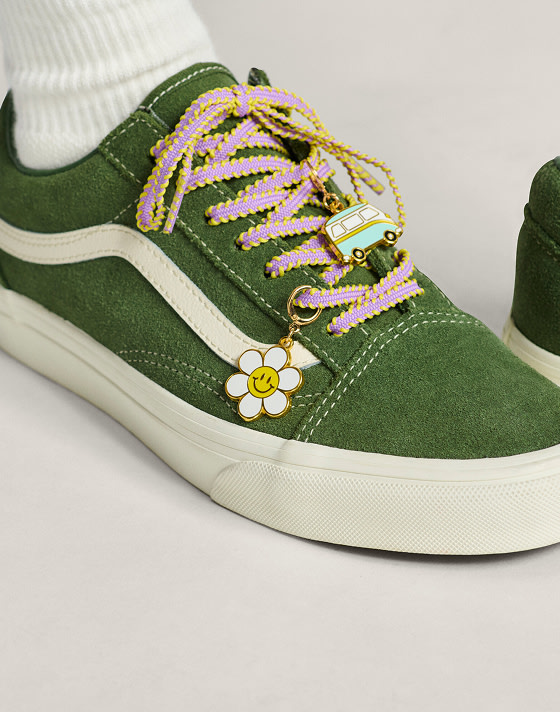 Close-up of some laces and charms on a green Old Skool shoe.