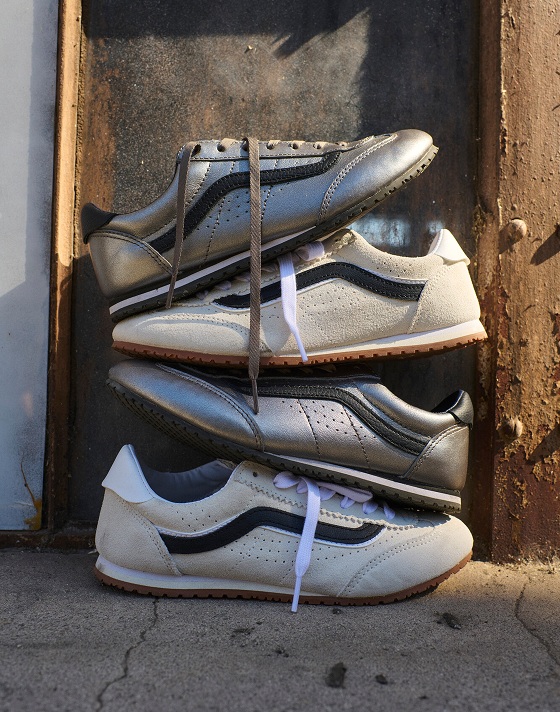 A pair of marshmallow white Super Lowpro are stacked mixed with silver Super Lowpro between the studs of a wall during golden hour.