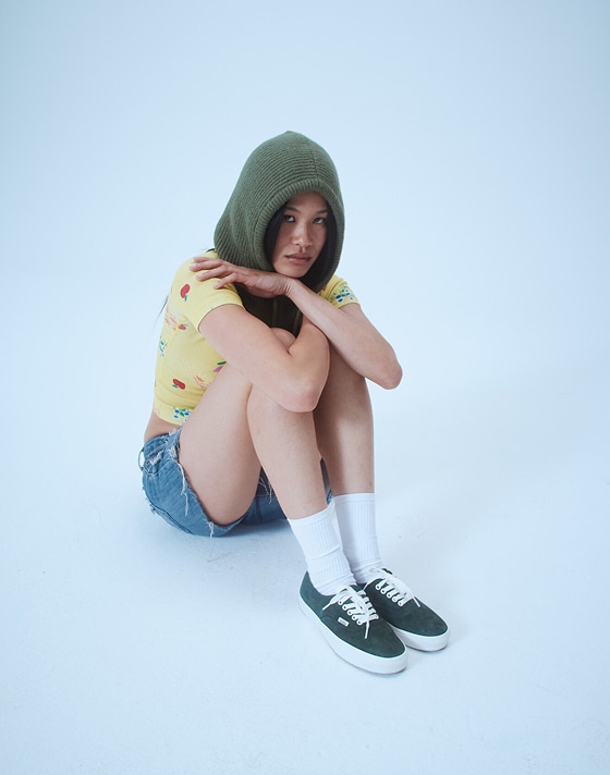 Model Justine sits in a photography studio wearing green pig suede Premium Authentic on the set of Open Set Los Angeles.
