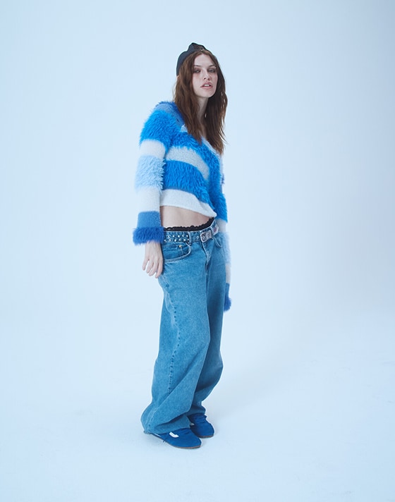 Kat, a designer, poses in a photography studio wearing blue Super Lowpro on Open Set Los Angeles.