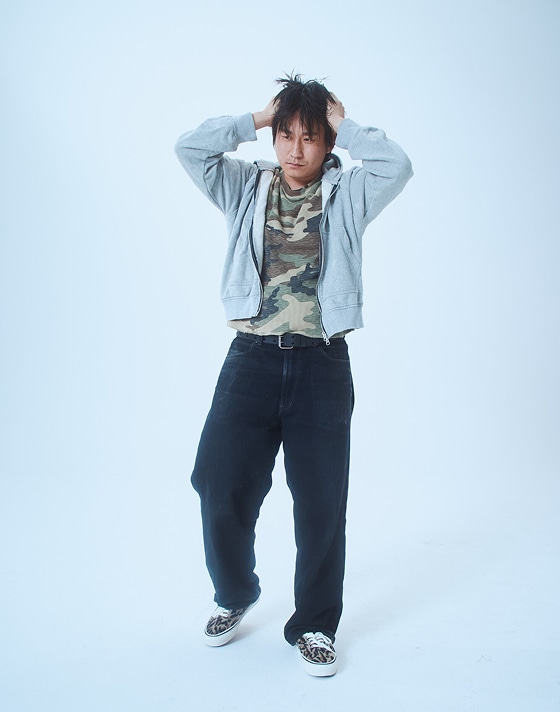 Masa, a designer, poses in a photography studio wearing Leopard Brown Premium Authentic on Open Set Los Angeles.