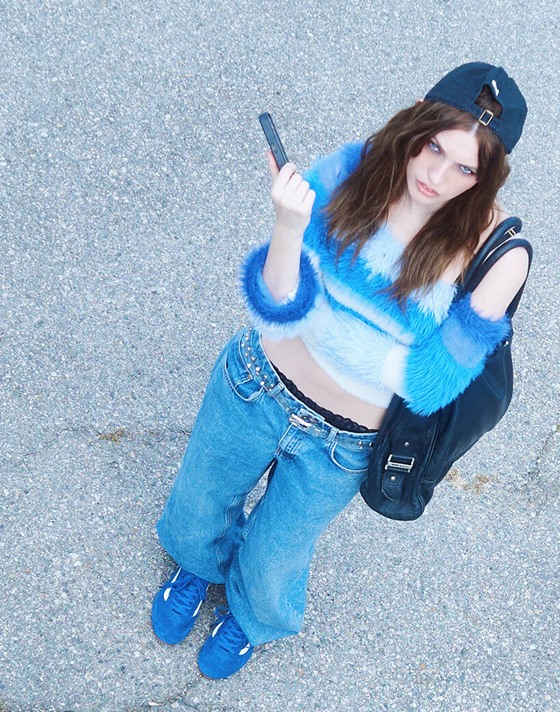 An overhead shot of designer Kat in a parking lot wearing blue jeans and blue Super Lowpro on the set of Open Set Los Angeles.