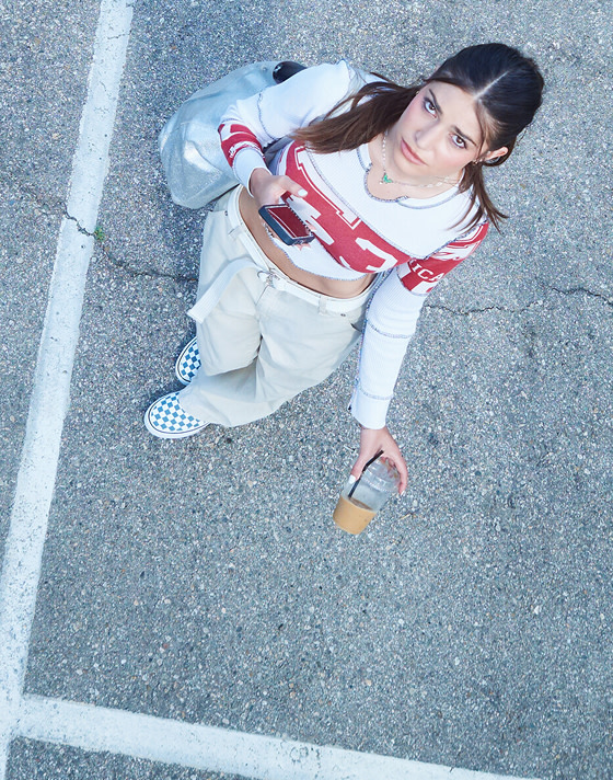 An overhead shot of director Gracie in a parking lot wearing stargazer blue Premium Classic Slip-On Checkerboard Shoe on Open Set Los Angeles.
