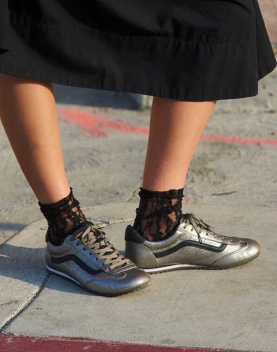 A knee-down shot of a woman posing on the sidewalk wearing the Francesca full skirt and silver Super Lowpro.