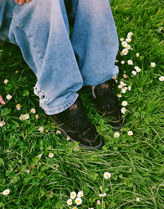 A close-up of the all-black Skate Half Cab in the grass.