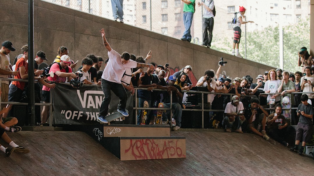 Professional skateboarder Kyle Walker skating down a ramp in front of a crowd.
