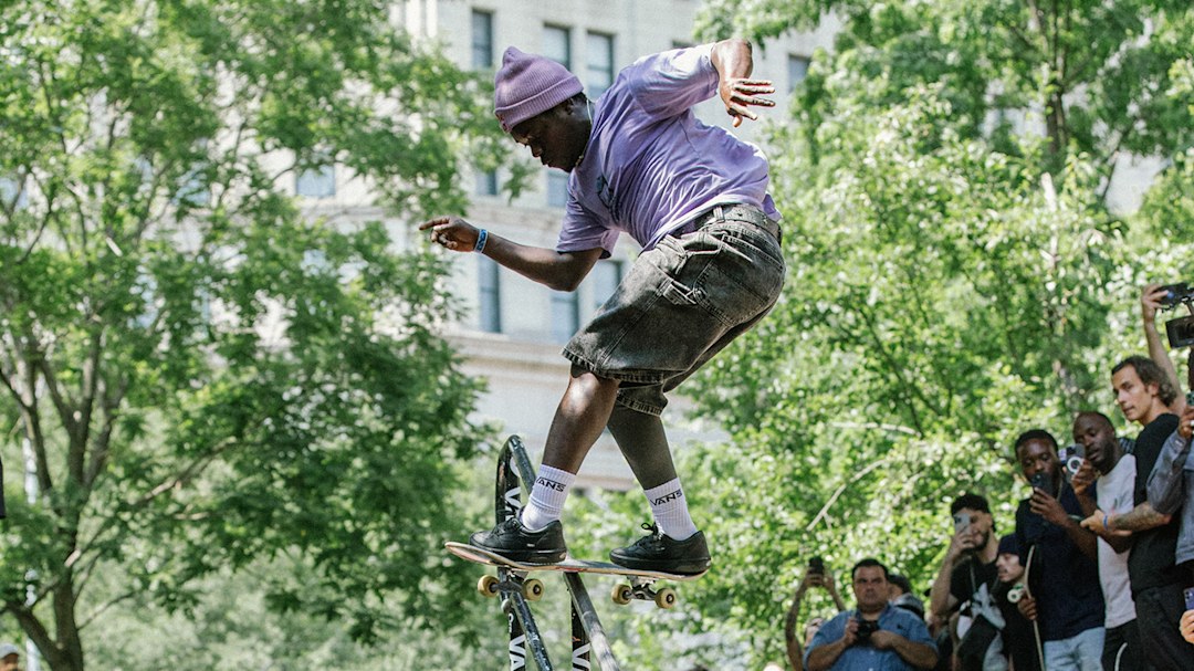 Pro skater Zion Wright doing a kickflip 50-50 down the railing of a set of stairs.