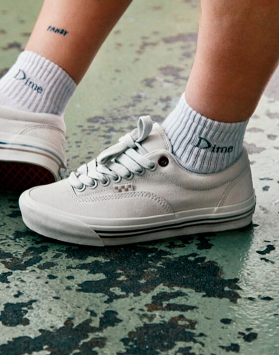 Gros plan de la Skate Era Stub blanche de Dime sur un plancher de béton peint.