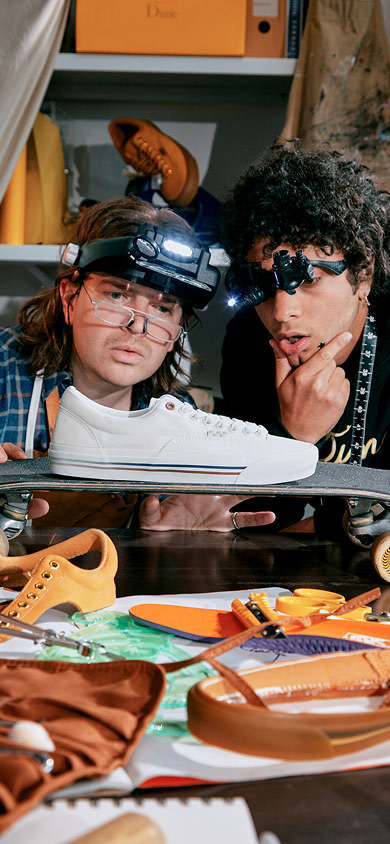 Gros plan de deux hommes portant des lunettes et des lampes frontales, fixant intensément la Skate Era Stub blanche de Dime dans un atelier.
