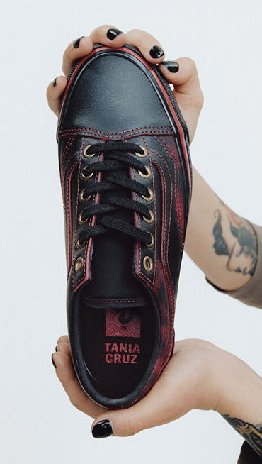 Vans Skater Tania Cruz holds up her Premium Old Skool in a photography studio with her name on the interior sole.