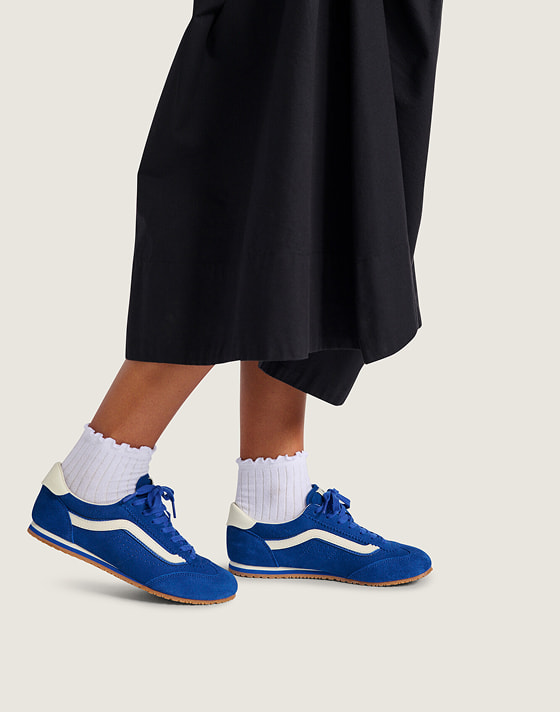 A girl wears the blue Super Lowpro styled with the black Francesca Full Skirt and white frill socks.
