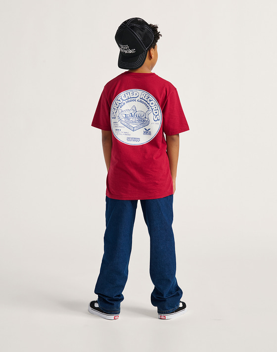 The back of a red Kids Scratched Records T-Shirt styled with blue jeans.