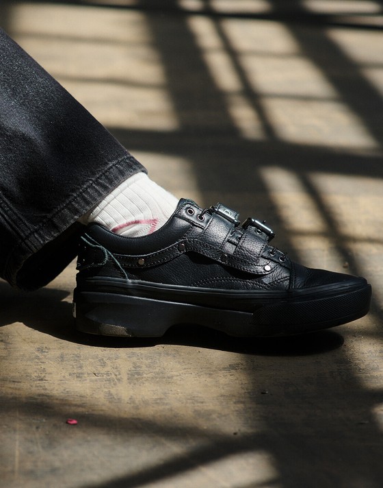 A close-up of Efron Danzig’s Premium Old Skool styled with black jeans in a warehouse.