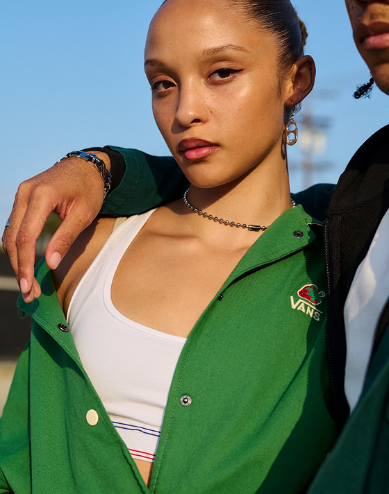 A woman looks into the camera wearing a green Van Doren Rubber Co. overshirt.