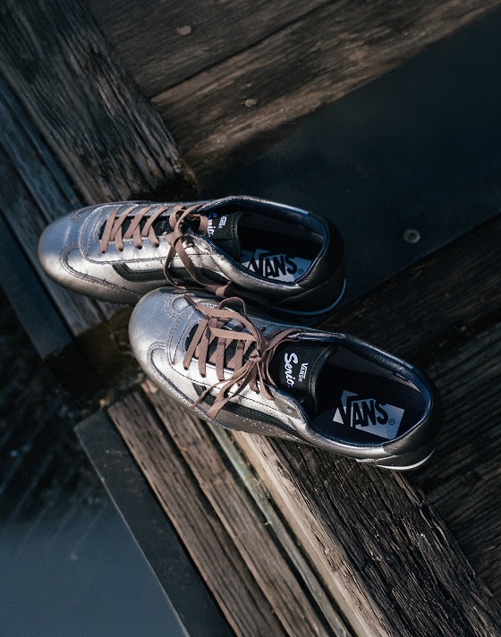 A pair of silver and black Super Lowpro lie on a wooden dock with their laces tied.