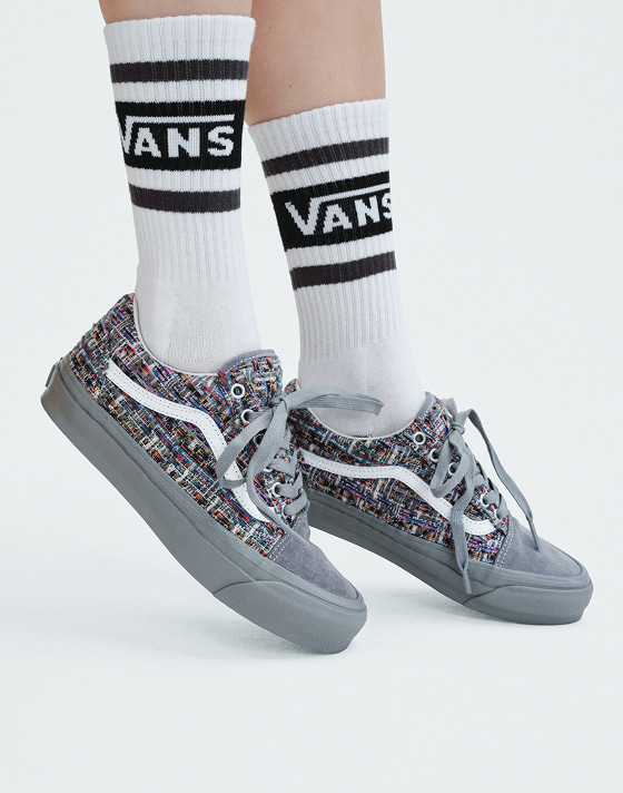 Close-up of someone standing on their toes wearing gray tweed Premium Old Skool in a photography studio.