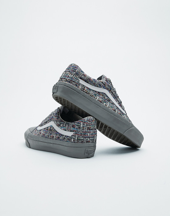A pair of gray tweed Premium Old Skool stacked on top of each other in a photography studio.