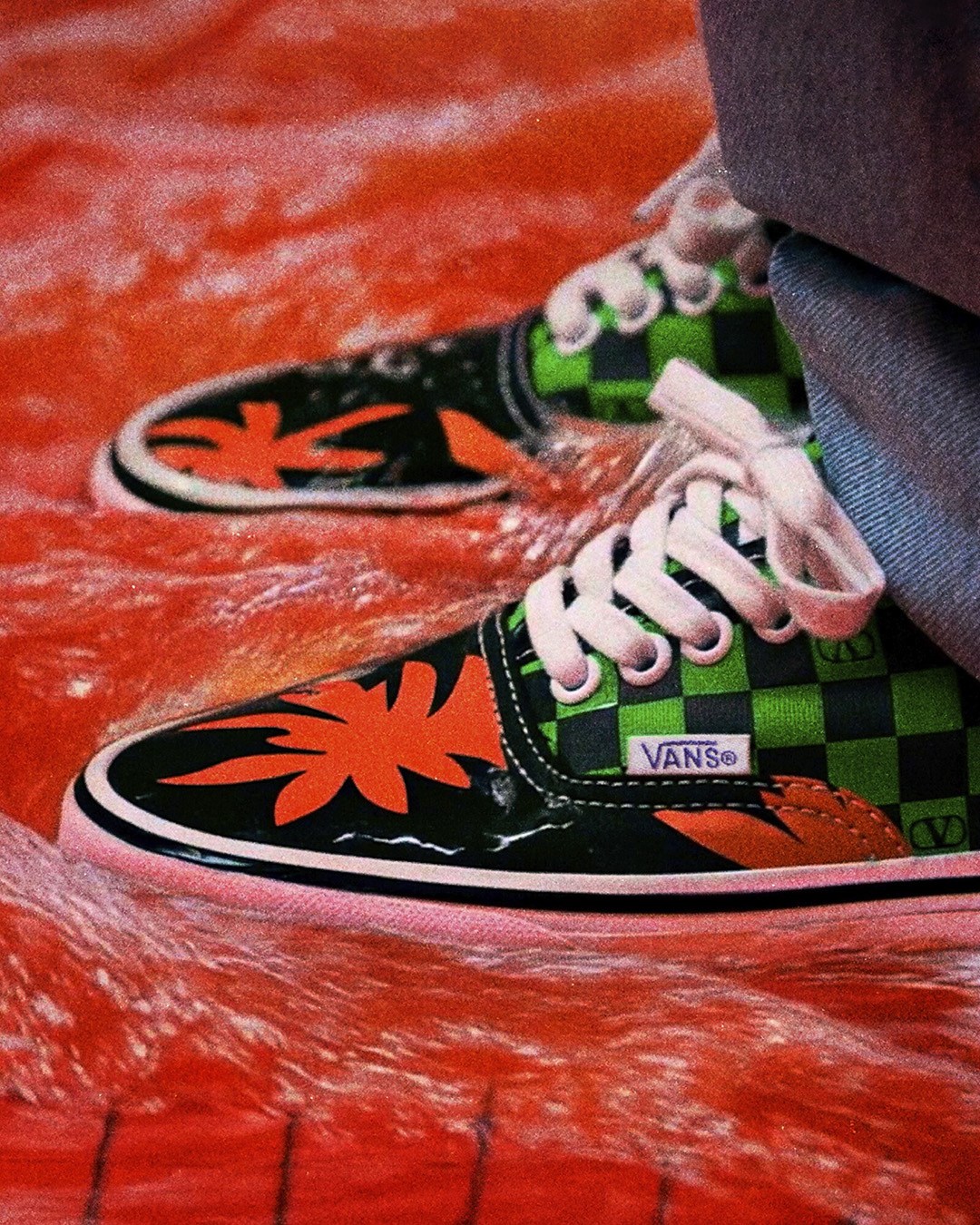 Green and orange tropical floral Valentino and Vans Authentic on a flooded floor.
