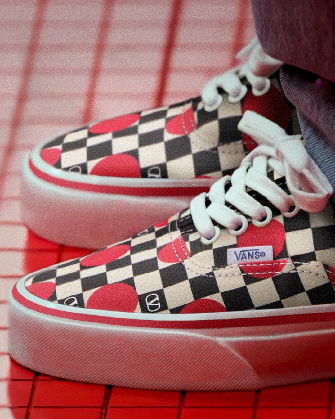 Red, black and white poka dot Valentino and Vans Authentic on a flooded floor.
