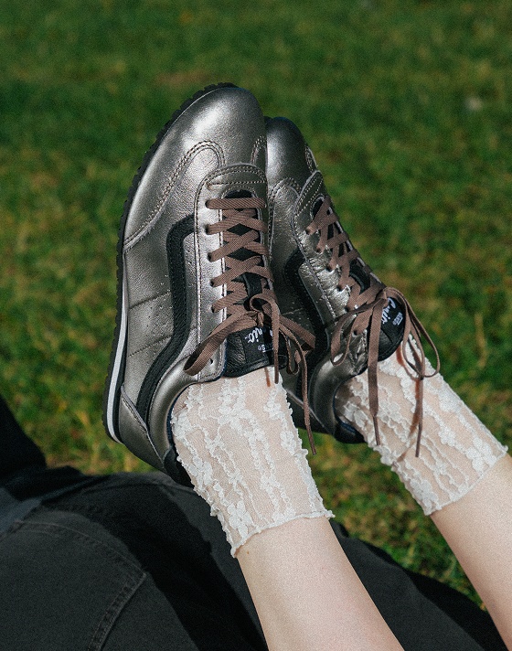 A close-up of someone in the park wearing gunmetal gray Premium Super Lowpro with white frill socks.
