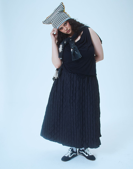 A woman poses in a photography studio wearing black and white Super Lowpro.