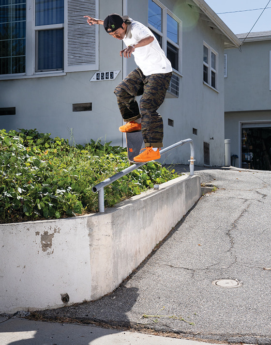 Vans Skate Team Rider Toa Sasaki grinding a rail wearing orange Skate Old Skool 36+ and camo pants from the United Through Skateboarding collection.