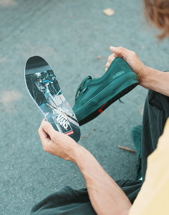 An over-the-shoulder shot of Vans Skate Team Rider Curren Caples looking at the photograph on the sole of the Curren.