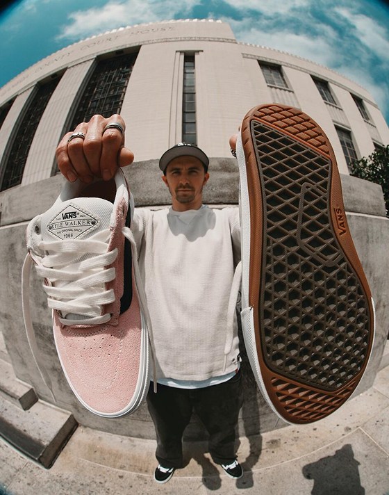 Vans Skate Team Rider Kyle Walker holding up his Kyle Walker Wafflecup skate shoes outside of a building.